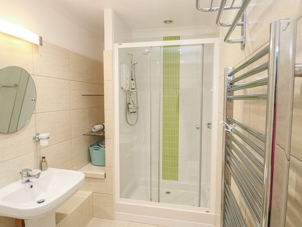 A bathroom with a shower, sink, and towel rail at Pump Cottage in Truro