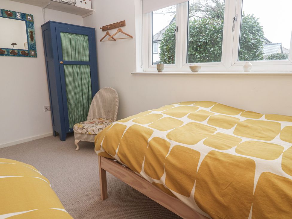 A bedroom with a bed and a wardrobe at Pump Cottage in Truro