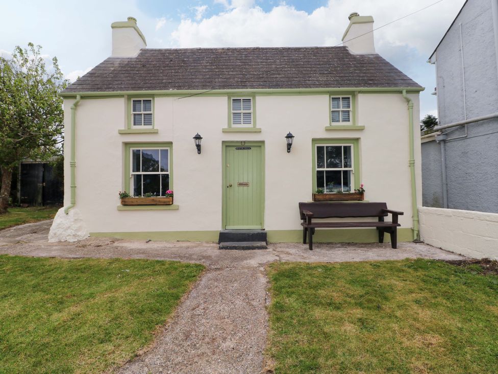 A cottage with a green door and windows at Beacon House Marloes near Little Haven