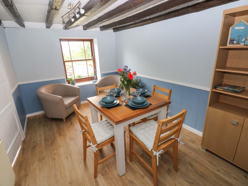 A dining room with a table set for four at Beacon House in Marloes near Little Haven