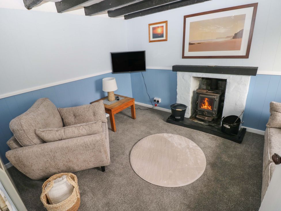 A living room with a fireplace and seating area at Beacon House Marloes near Little Haven