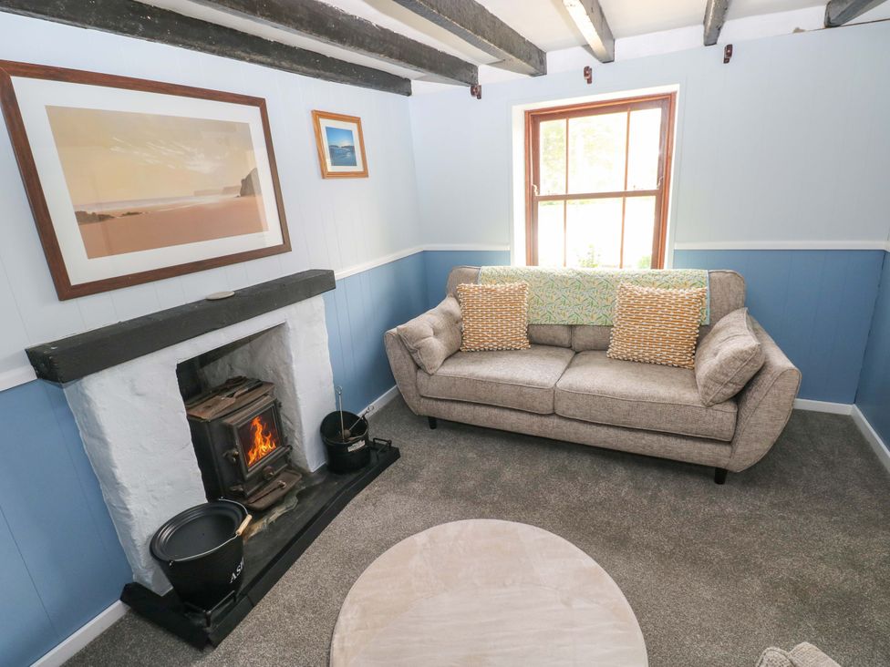 A living room with a sofa and fireplace at Beacon House in Marloes near Little Haven