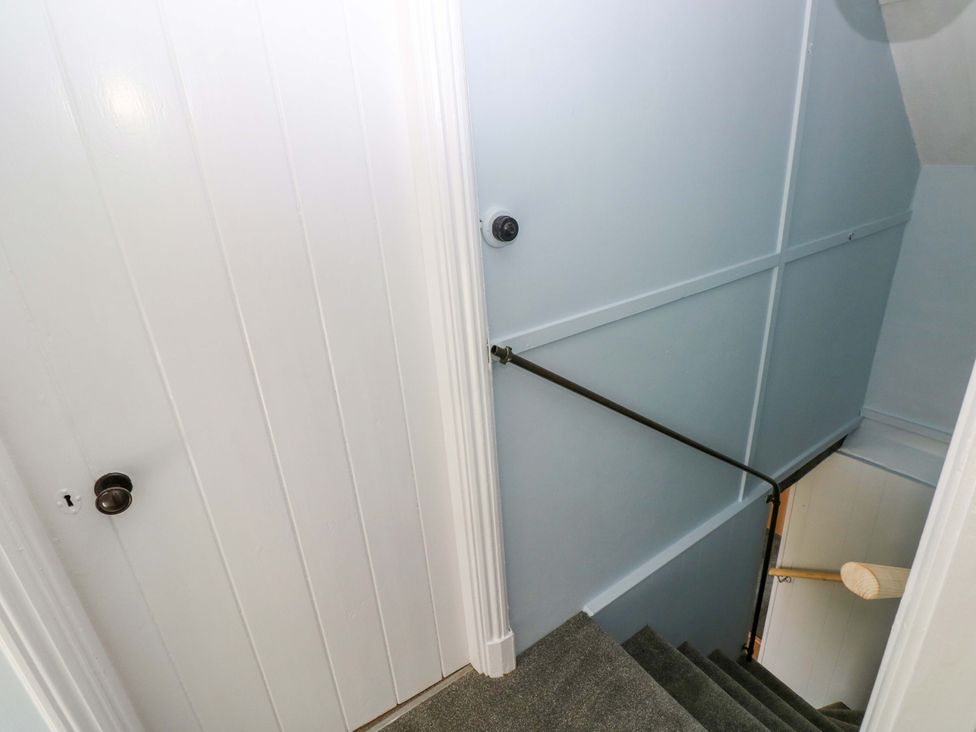 A staircase with a handrail and door at Beacon House Marloes near Little Haven