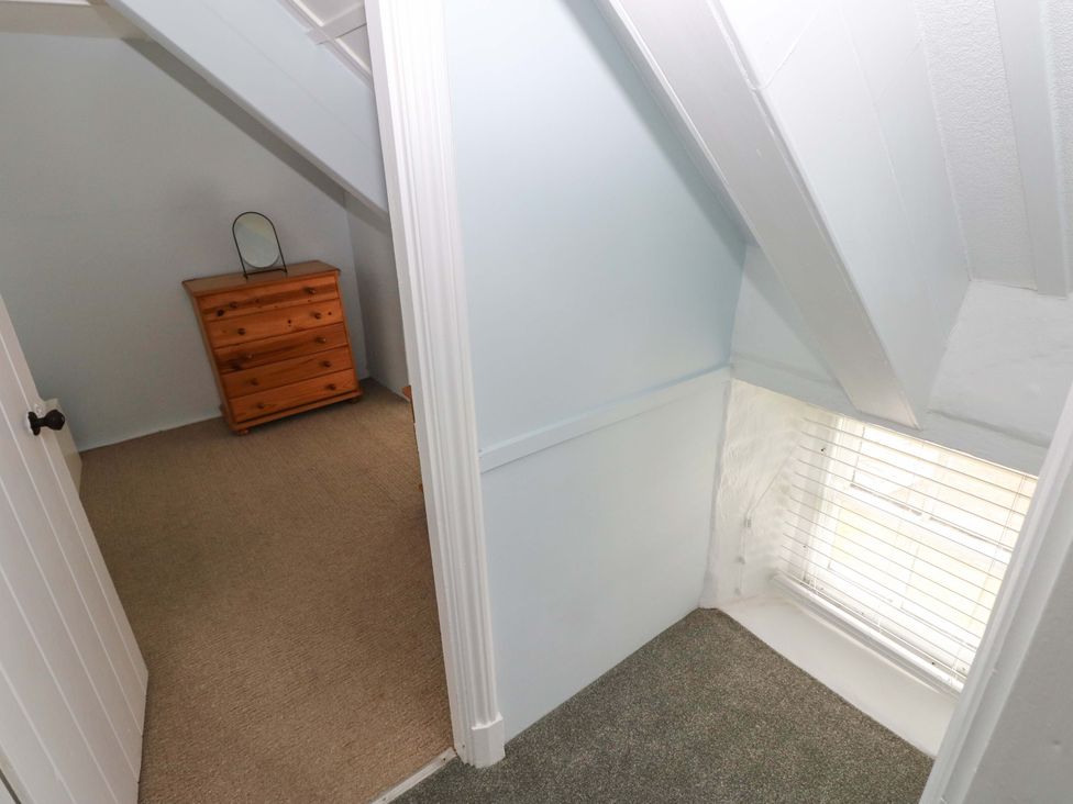 A bedroom with a dresser and a window at Beacon House Marloes near Little Haven