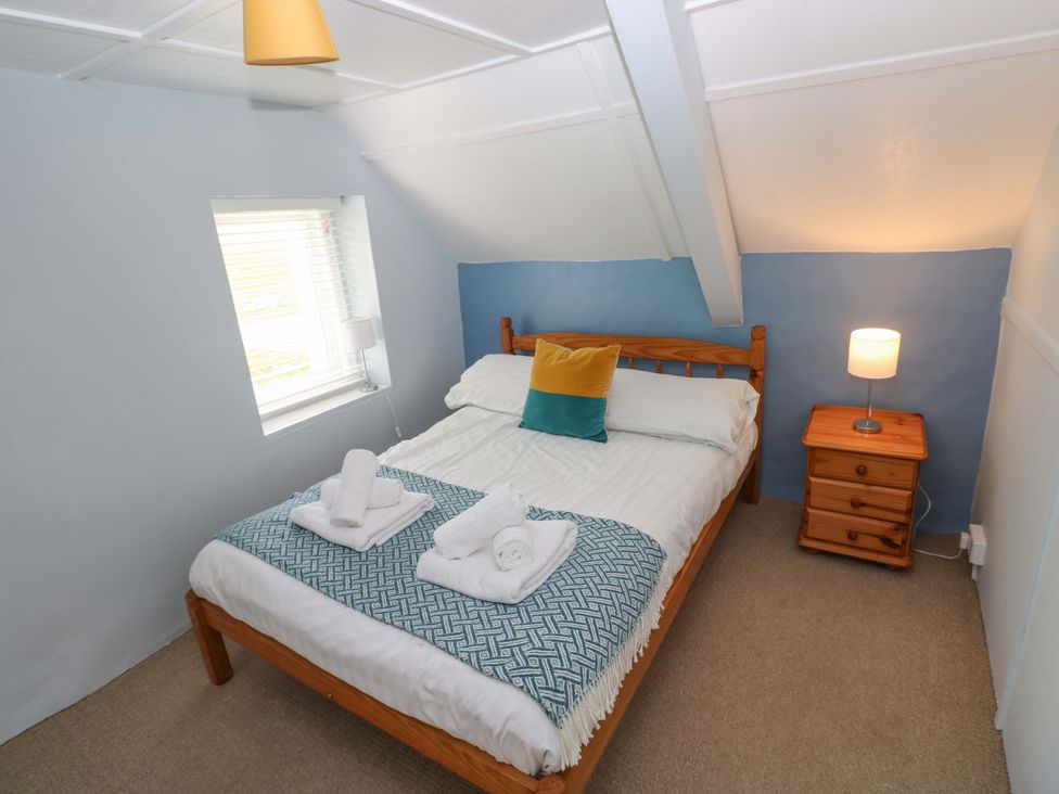 A bedroom with a bed and bedside table at Beacon House Marloes near Little Haven