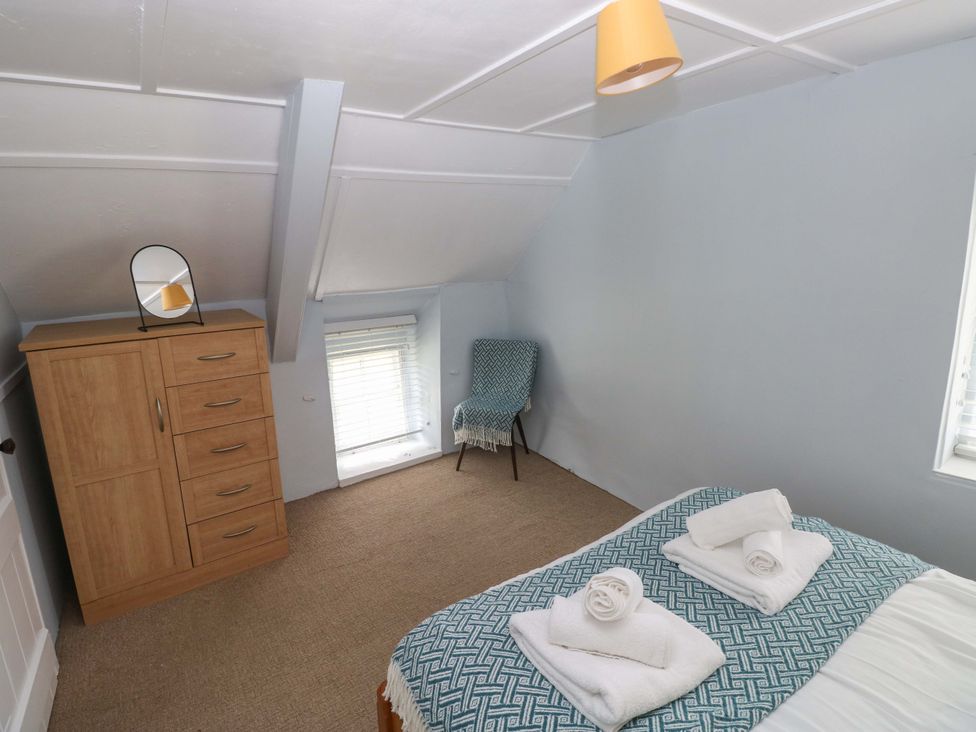 A bedroom with a bed and dresser at Beacon House Marloes near Little Haven