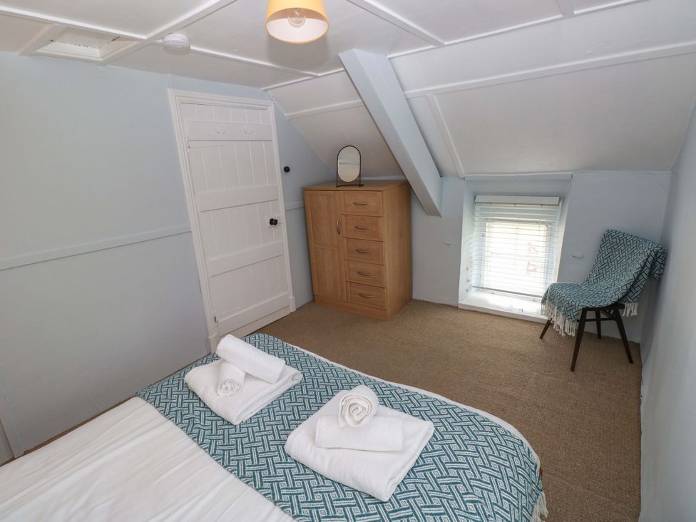 A bedroom with a bed and dresser at Beacon House Marloes near Little Haven