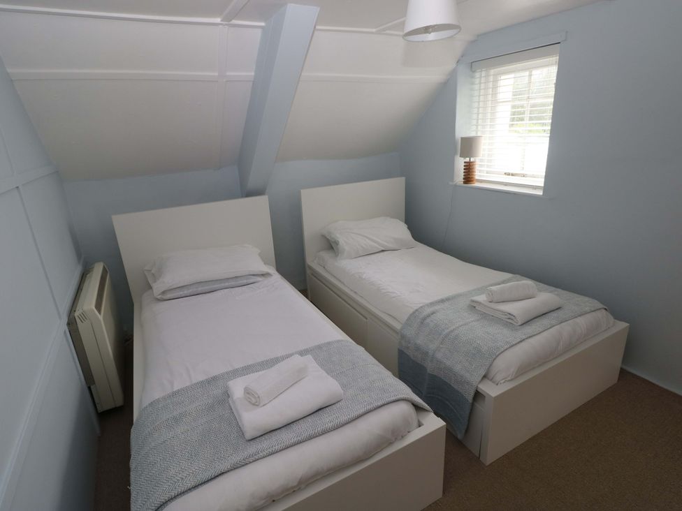 A bedroom with two beds and a lamp at Beacon House Marloes near Little Haven