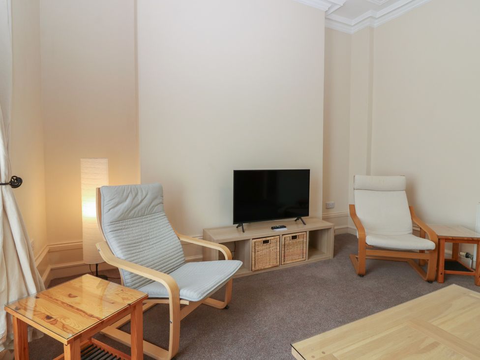 A living room with two armchairs and a television at Pincerna Apartment Suite 1a Aberdeen