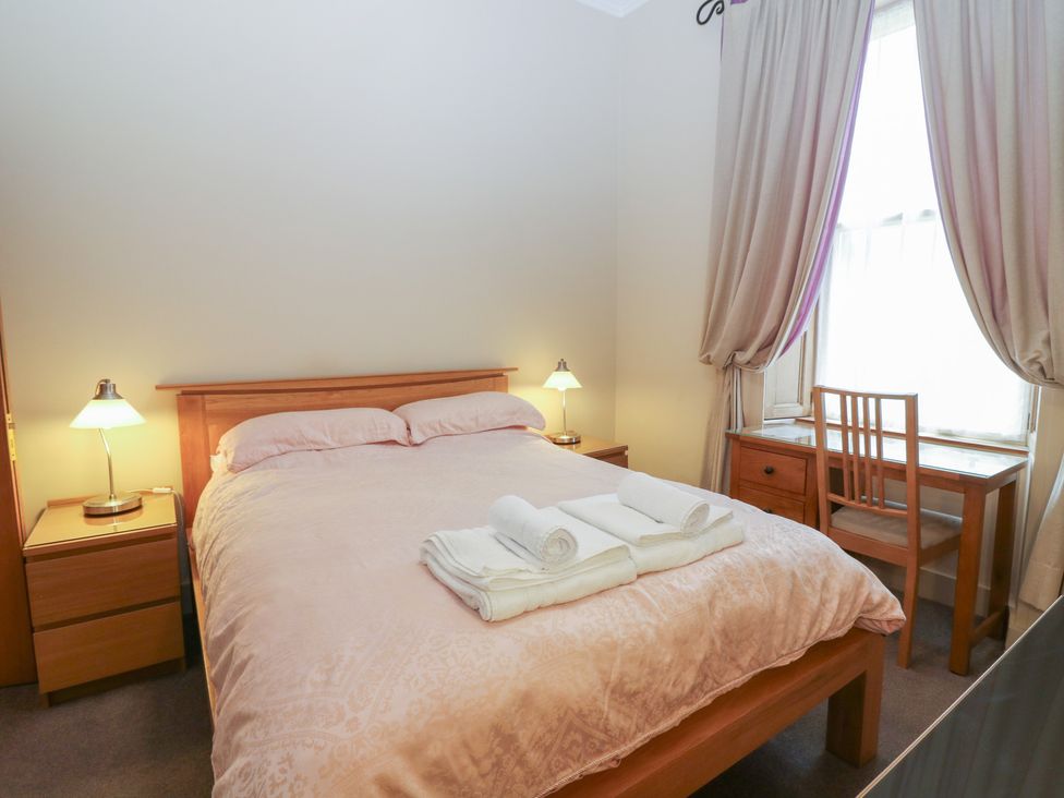 A bedroom with a bed and a desk at Pincerna Apartment Suite 1a in Aberdeen
