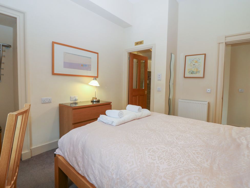 A bedroom with a bed and a chair at Pincerna Apartment Suite 1a in Aberdeen