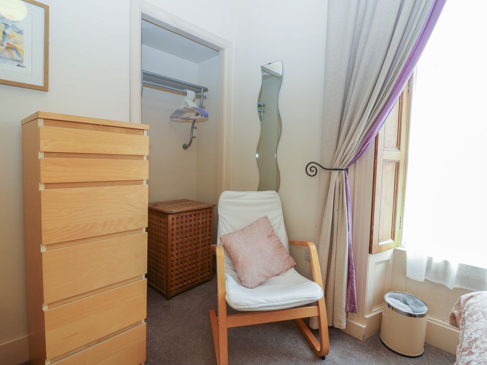 A bedroom with a dresser and a rocking chair at Pincerna Apartment Suite 1a Aberdeen