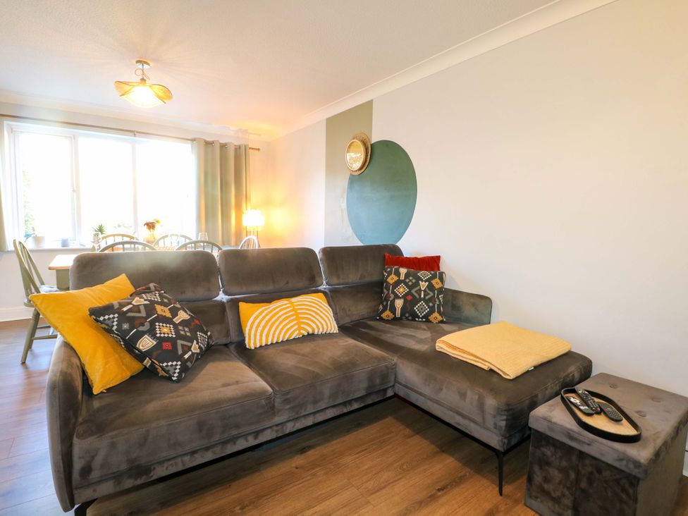 A living room with a sofa and dining area at Flat 16 in Farnham