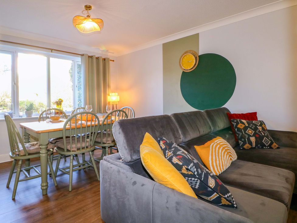 A living room with a sofa and dining table at Flat 16 in Farnham