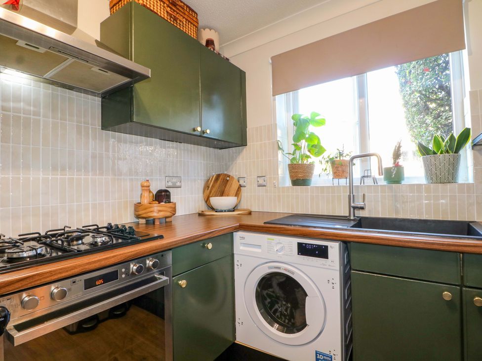 A kitchen with a washing machine and stove at Flat 16 in Farnham