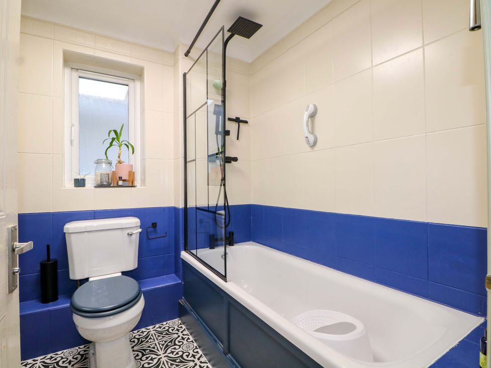 A bathroom with a bathtub and toilet at Flat 16 in Farnham