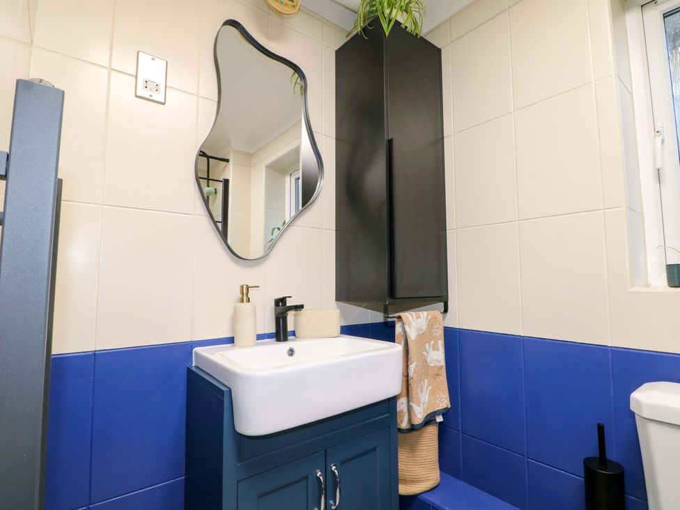 A bathroom with a sink and mirror at Flat 16 in Farnham