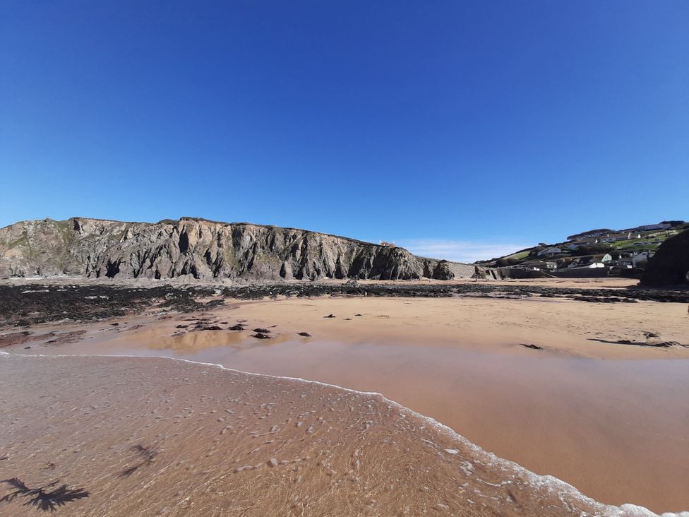 A beach with cliffs and houses at Hope Cove in Kingsbridge