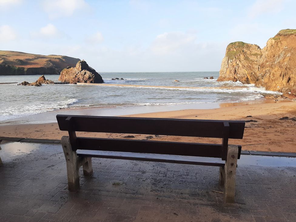 A beach with a bench overlooking the sea at Hope Cove in Kingsbridge