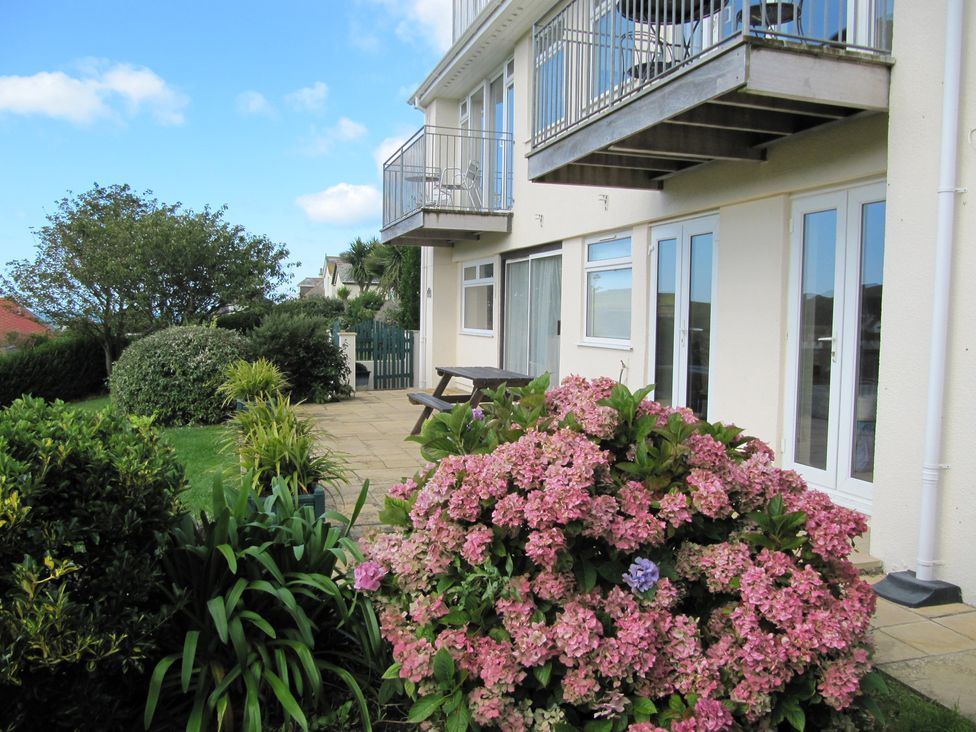 An outdoor area with a building, balcony, and flowers at Hope Cove near Kingsbridge