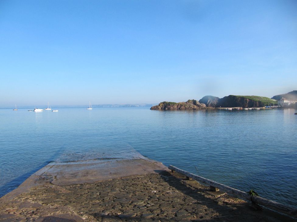 A view of boats on water with a rocky shoreline at Hope Cove near Kingsbridge