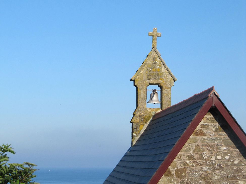 A bell tower with a cross and roof at Hope Cove near Kingsbridge