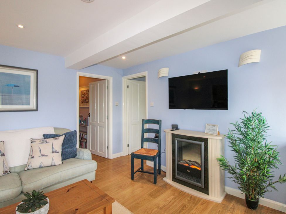 A living room with a sofa and television at Quay Sands, Hope Cove