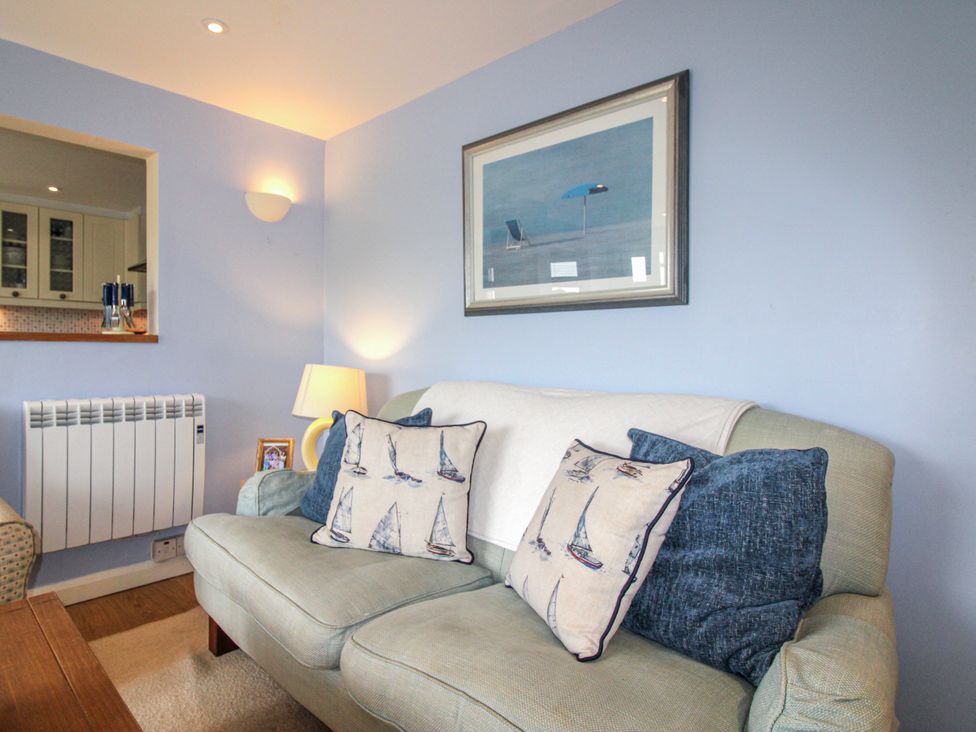 A living room with a sofa and cushions at Quay Sands, Hope Cove