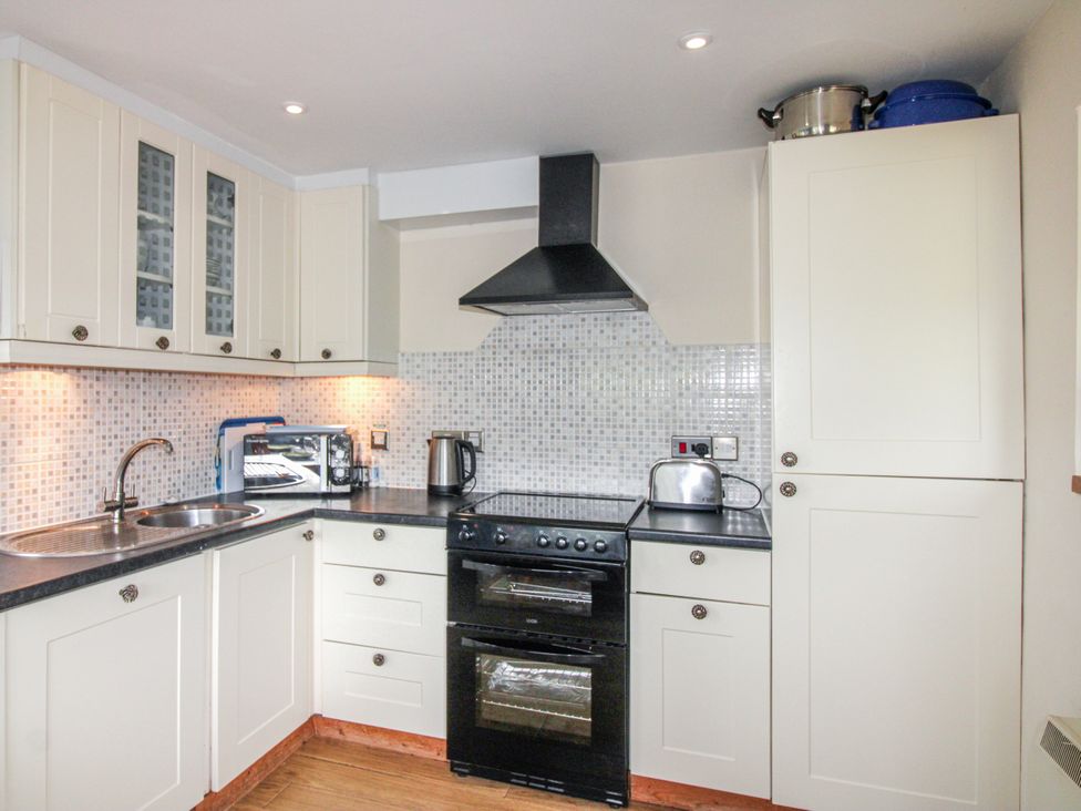 A kitchen with an oven, sink, and microwave at Quay Sands, Hope Cove