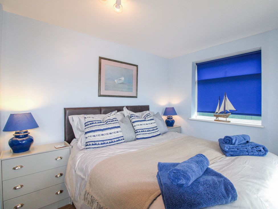 A bedroom with a bed and a lamp at Quay Sands, Hope Cove