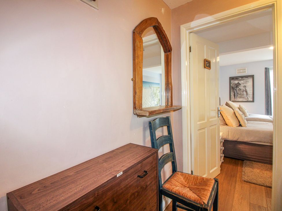 A hallway with a mirror and chest at Quay Sands, Hope Cove