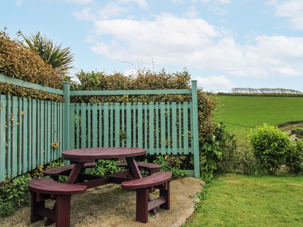 A garden with a picnic table and fence at Quay Sands, Hope Cove