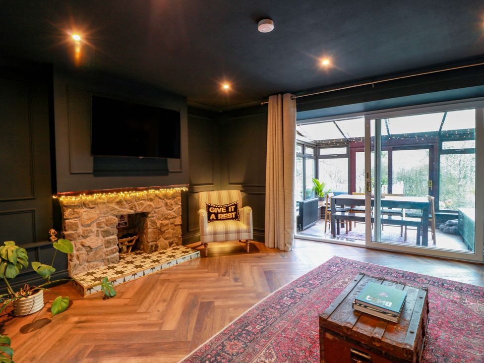 A living room with a fireplace and sliding doors at 7 Brewery Pool in Newton Stewart