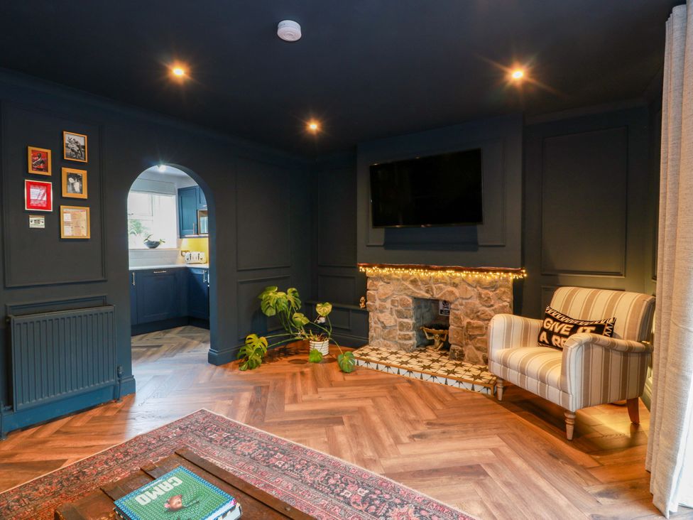 A living room with an armchair and fireplace at 7 Brewery Pool in Newton Stewart