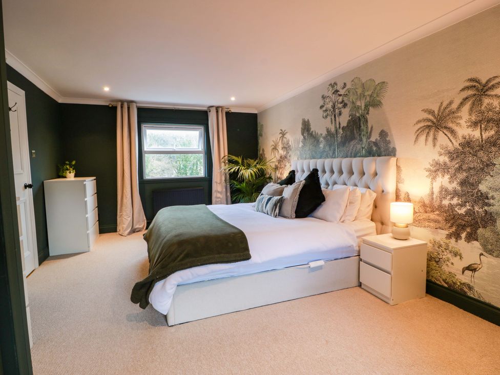 A bedroom with a bed and decorative wall mural at 7 Brewery Pool in Newton Stewart