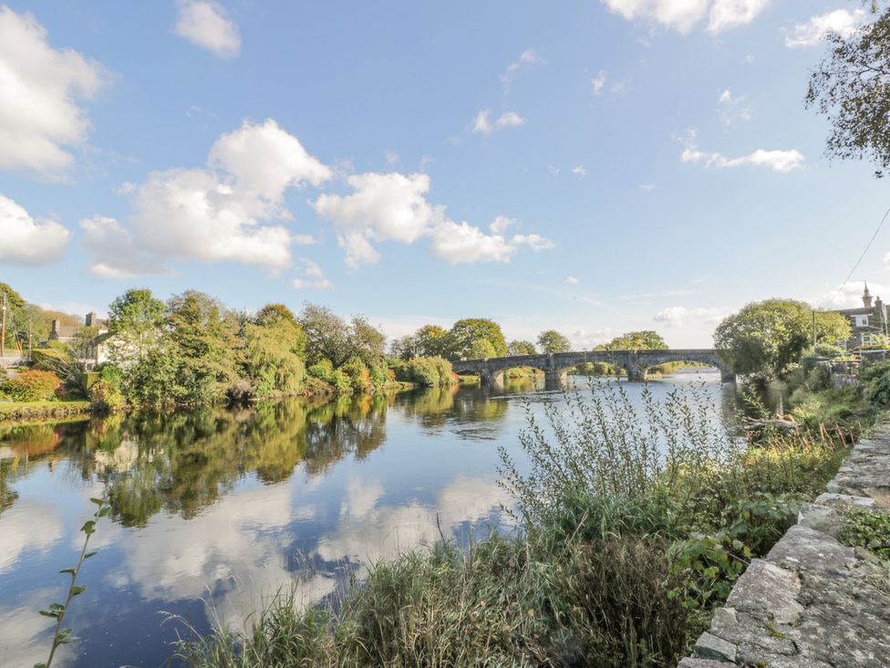 A river with a bridge and trees beside it at 7 Brewery Pool in Newton Stewart