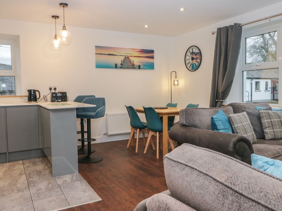 A living room with a kitchen area and a dining table at 6 Hallin Fell in Penrith