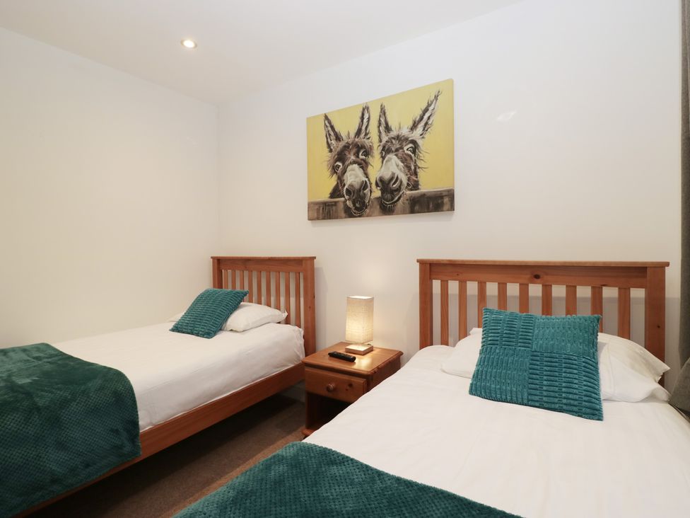 A bedroom with two beds and a nightstand at 6 Hallin Fell in Penrith