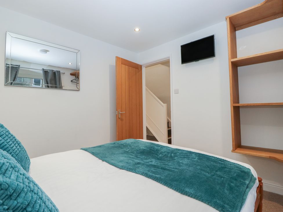 A bedroom with a bed and mirror at 6 Hallin Fell in Penrith