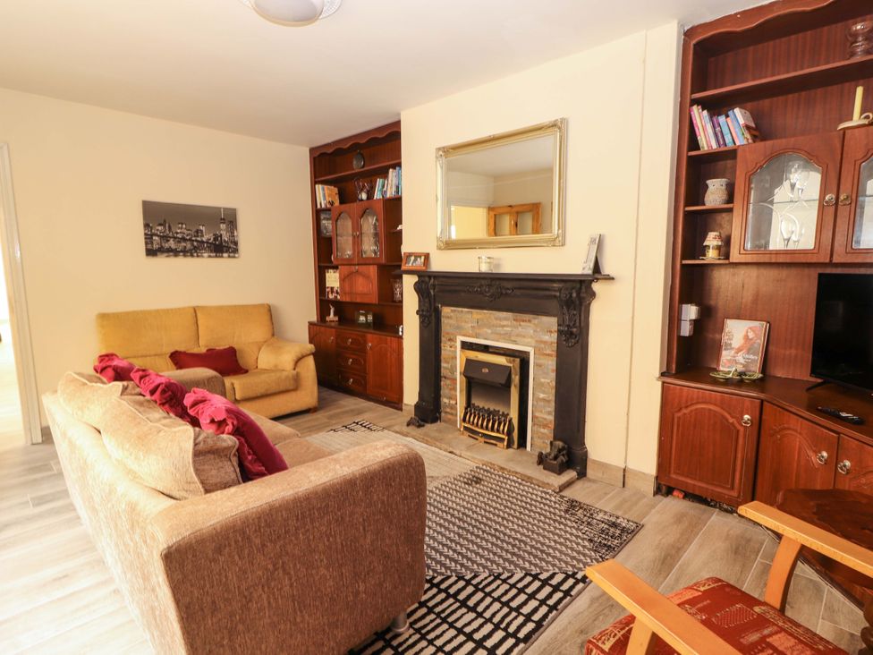 A living room with a fireplace and sofa at Macmathuna in Kilrush, County Clare