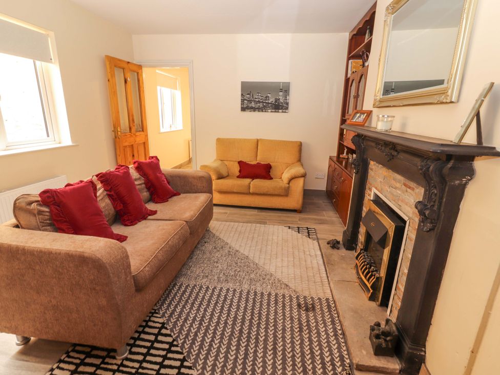 A living room with a sofa and armchair at Macmathuna, Kilrush, County Clare