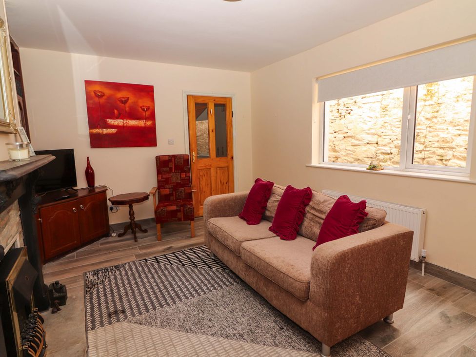 A living room with a sofa and television at Macmathuna in Kilrush, County Clare