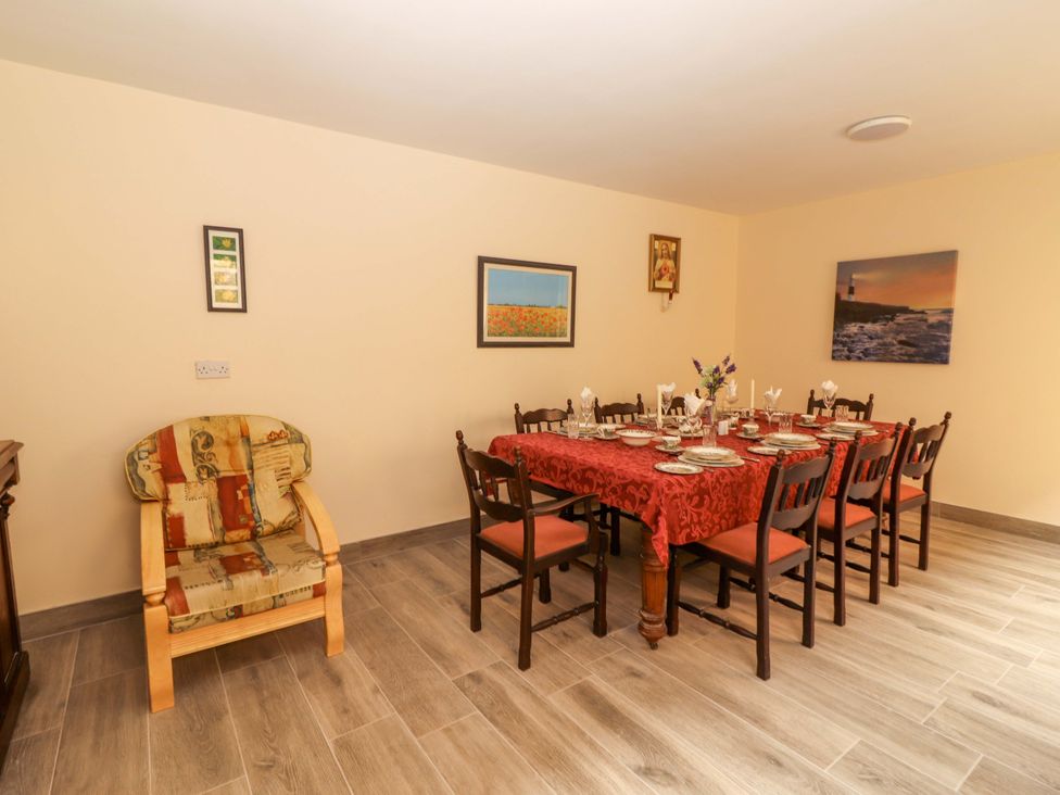 A dining room with a table set for meals at Macmathuna, Kilrush, County Clare