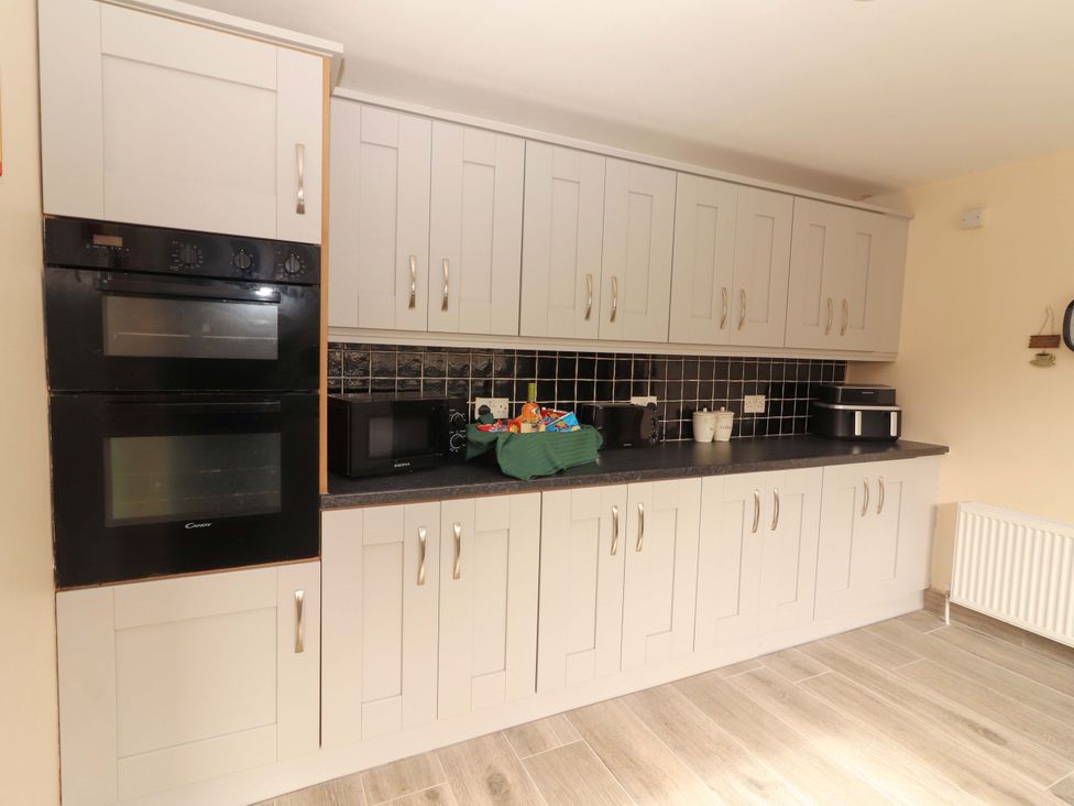 A kitchen with appliances and cabinets at Macmathuna in Kilrush, County Clare
