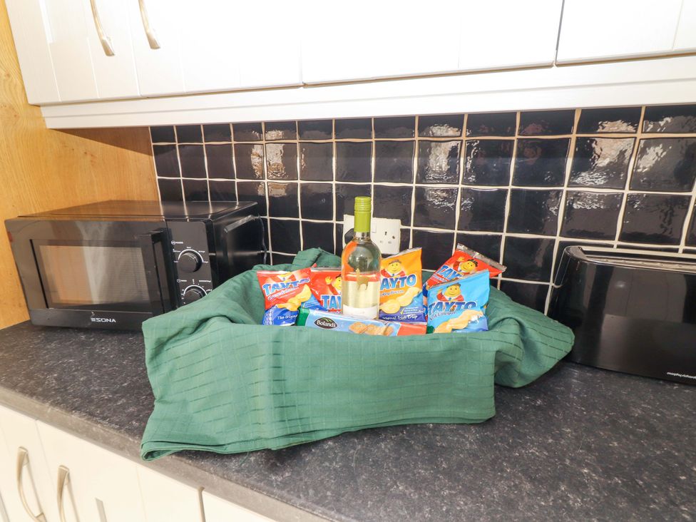 A kitchen with a bottle of wine and snacks on a countertop at Macmathuna, Kilrush, County Clare