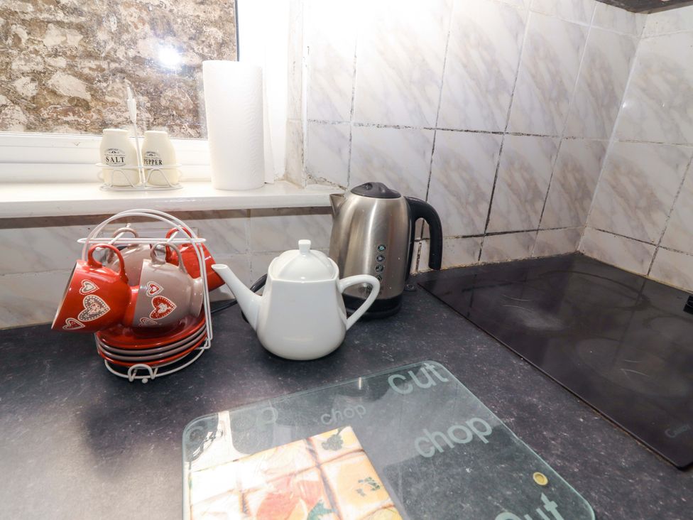 A kitchen counter with mugs, a teapot, kettle, salt and pepper shakers at Macmathuna, Kilrush, County Clare