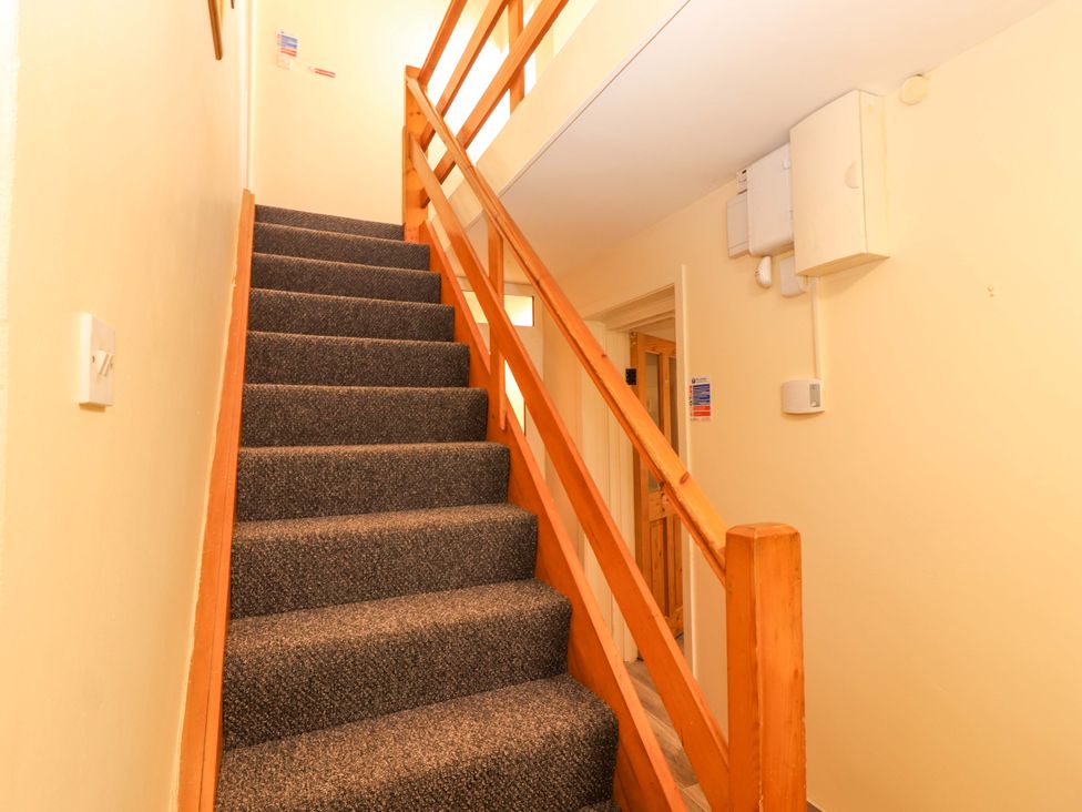 A staircase with a handrail and doorway at Macmathuna, Kilrush, County Clare