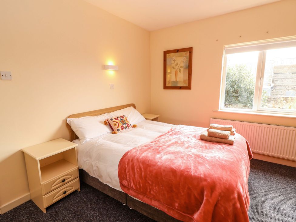 A bedroom with a bed and nightstand at Macmathuna, Kilrush, County Clare