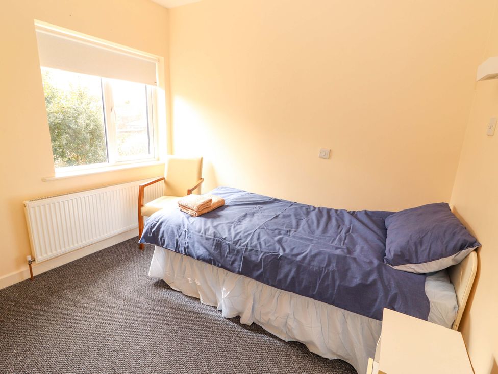 A bedroom with a bed and chair at Macmathuna in Kilrush, County Clare