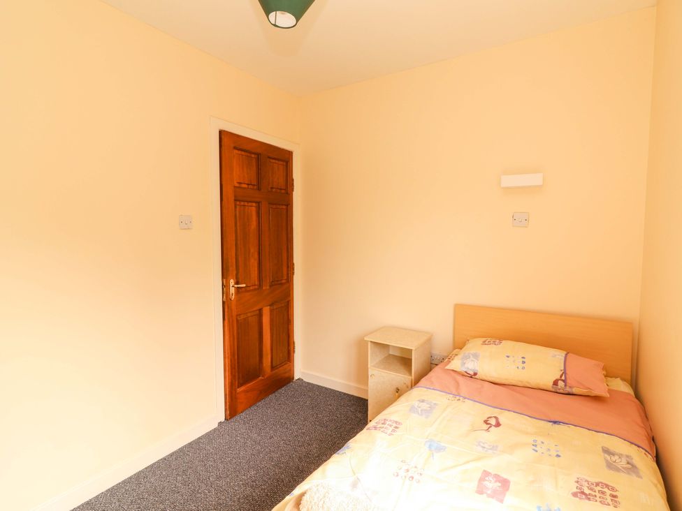 A bedroom with a bed and nightstand at Macmathuna, Kilrush, County Clare